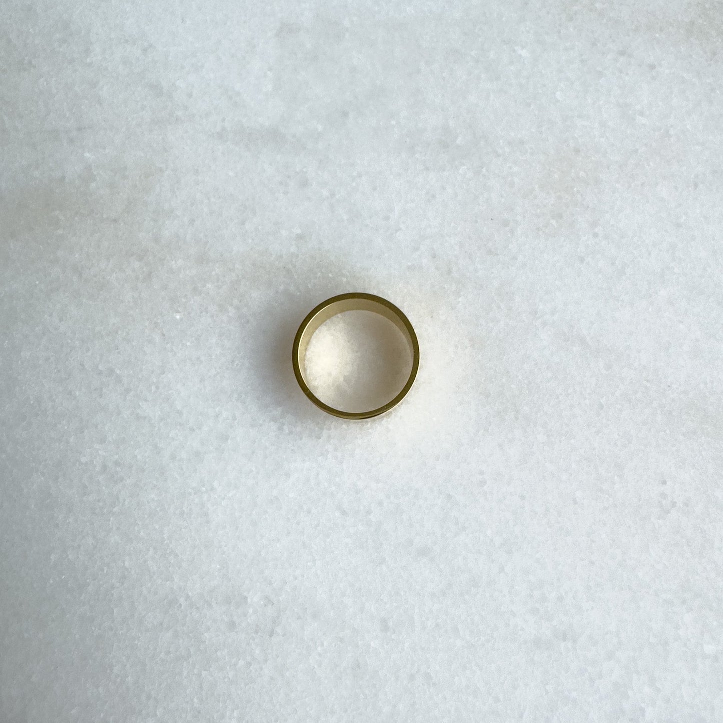 Gold band on a textured white surface