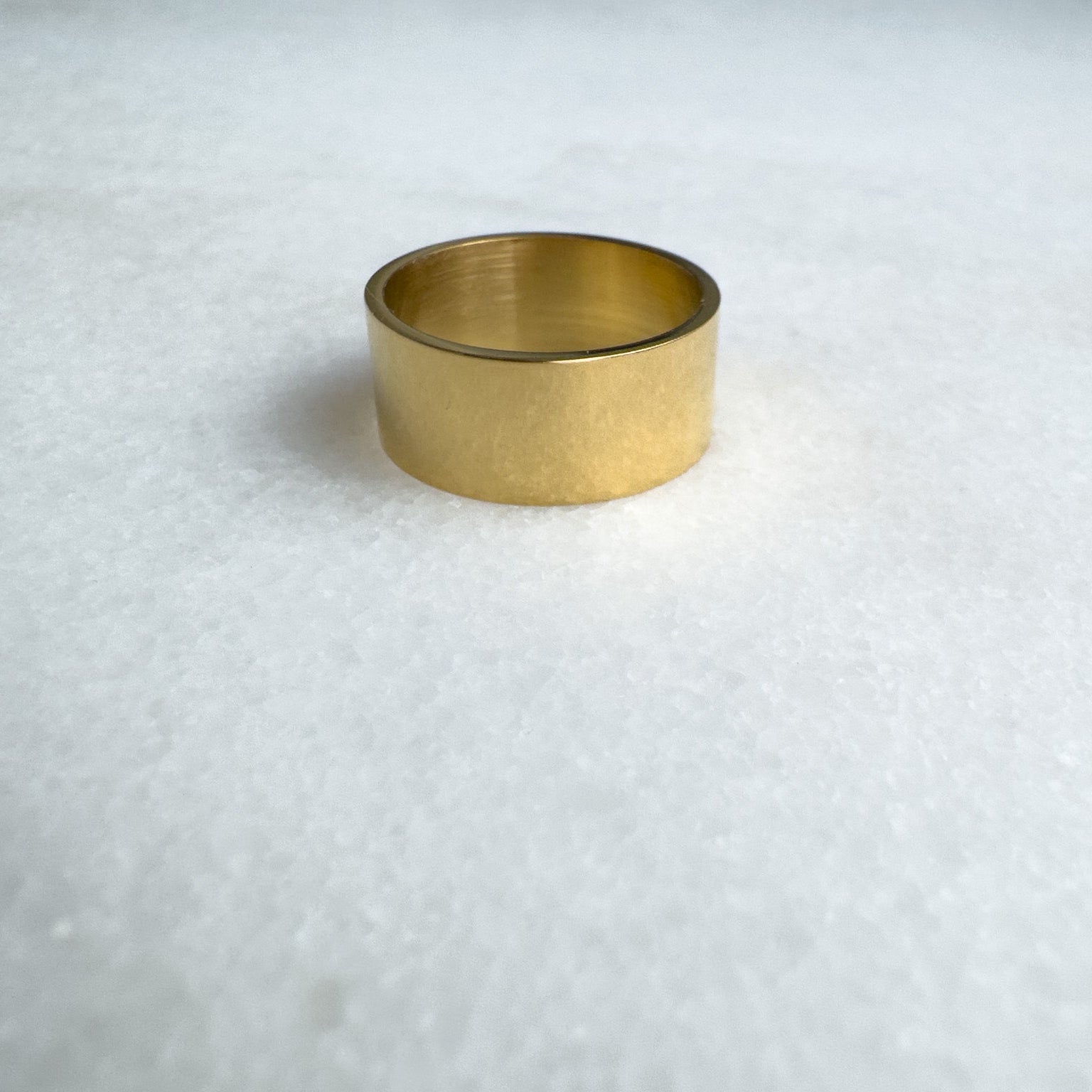 Gold metal band on a textured white background