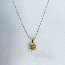 Load image into Gallery viewer, Gold necklace with a round pendant on a white background
