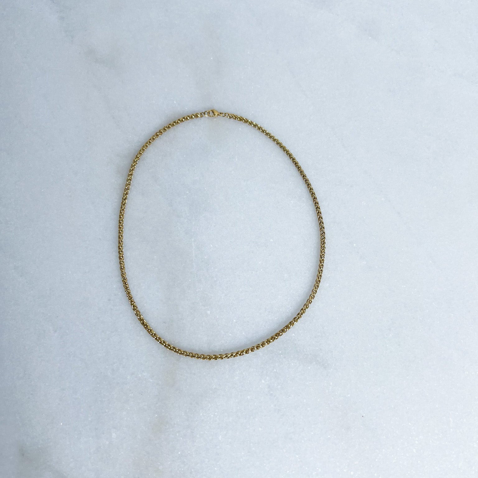 Gold Franco chain on marble background