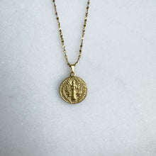 Load image into Gallery viewer, Gold necklace with a round pendant on a light gray background
