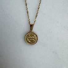 Load image into Gallery viewer, Gold necklace with a round pendant on a light gray background
