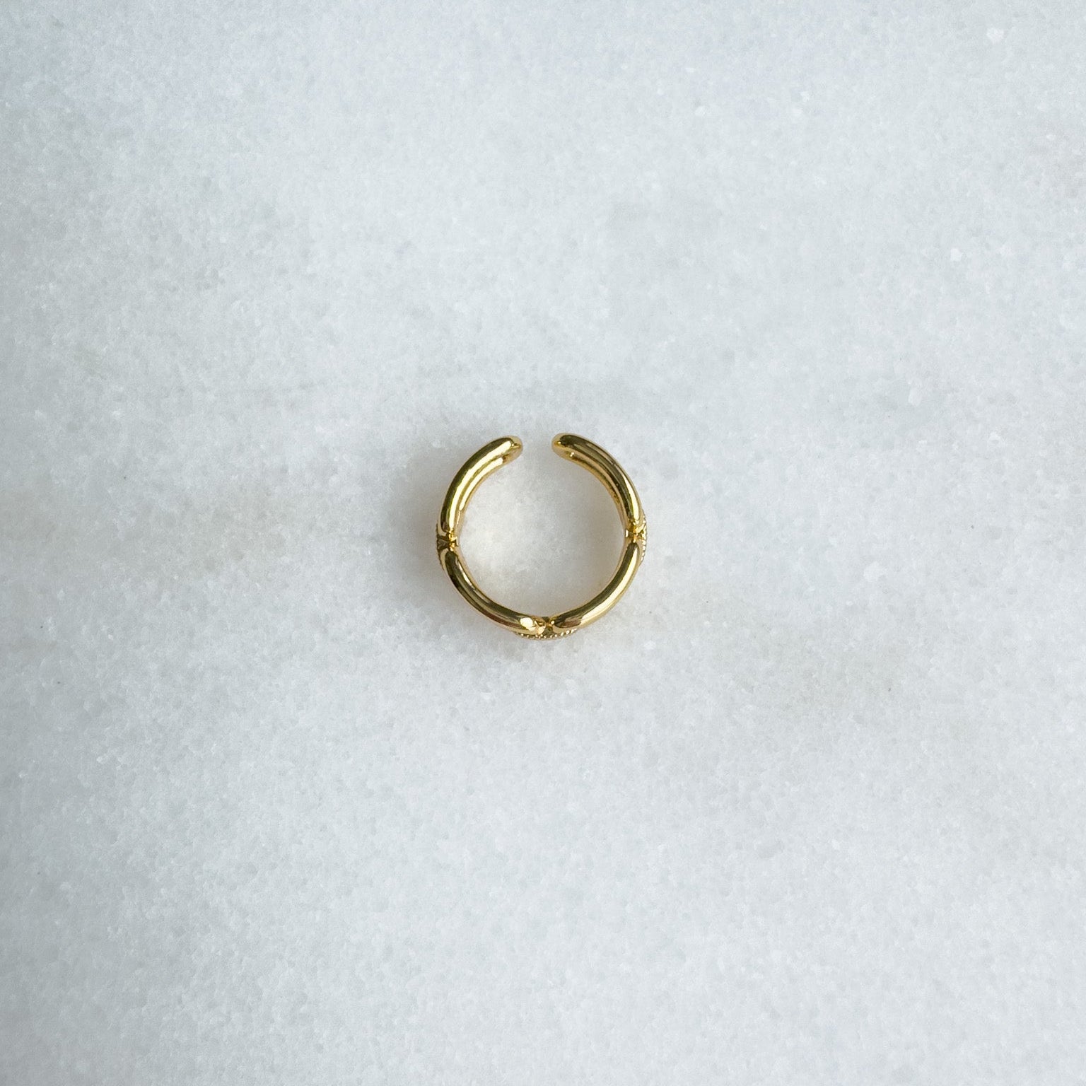 Gold link ring on a light gray background
