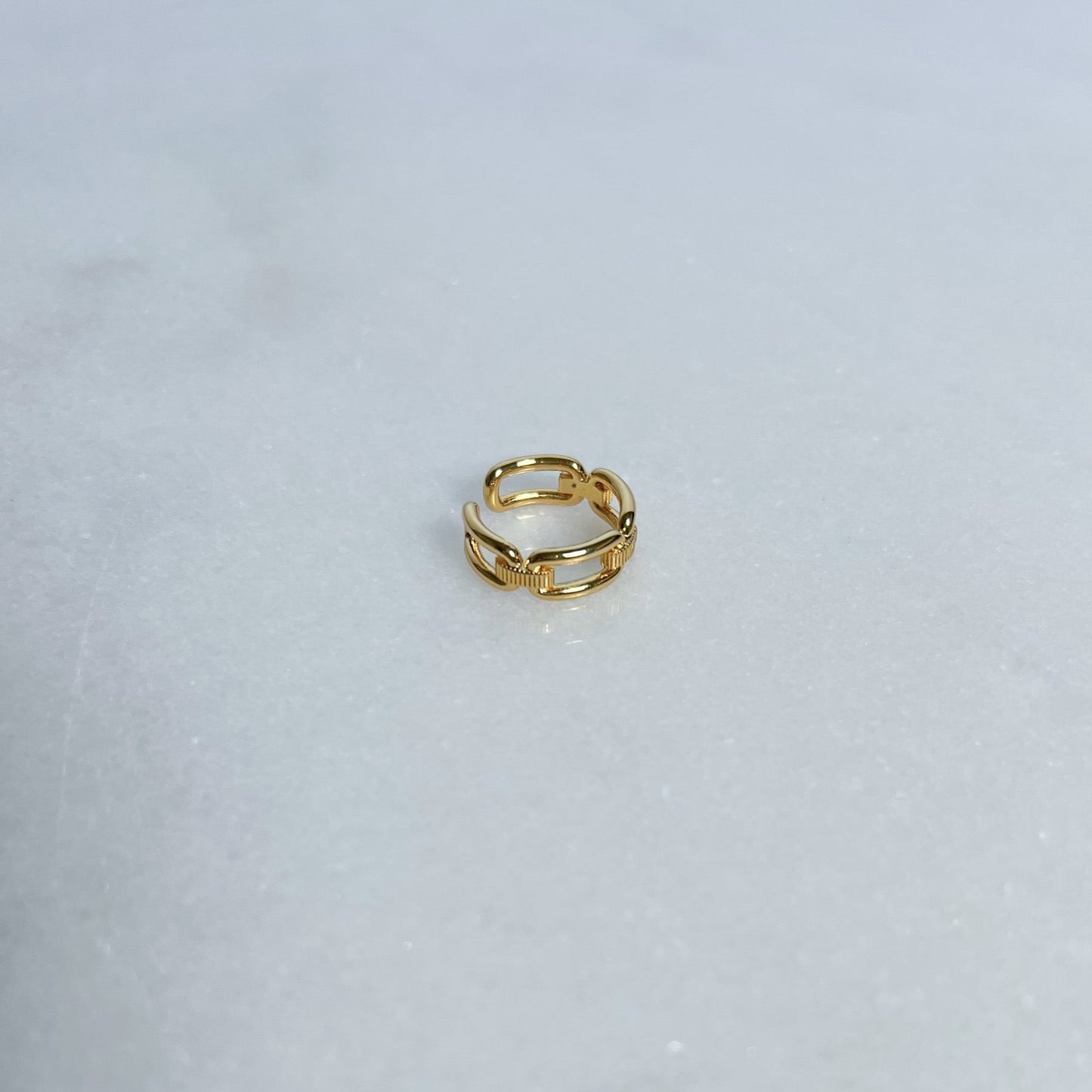 Gold link ring on a light gray background