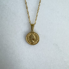 Load image into Gallery viewer, Gold necklace with a round pendant on a light gray background
