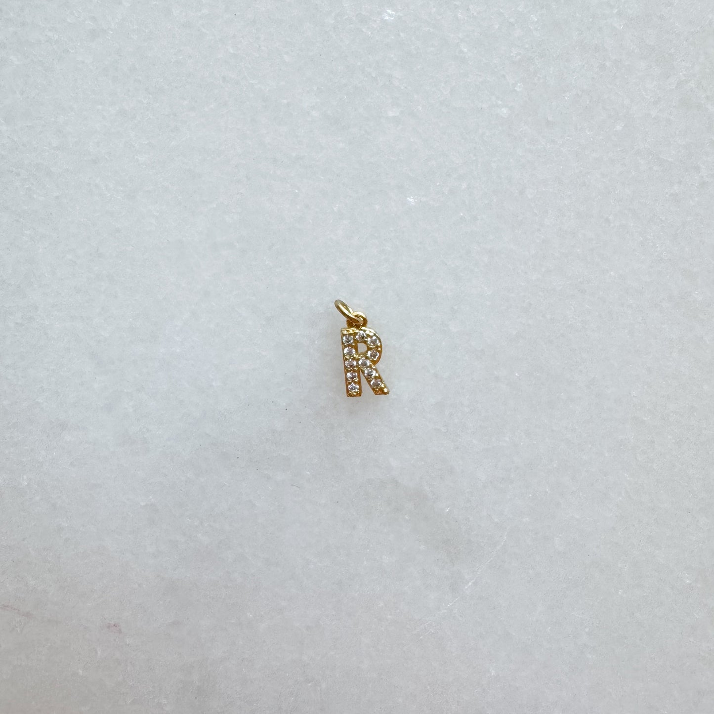 Diamond pavé initial charm set in gold, letter R