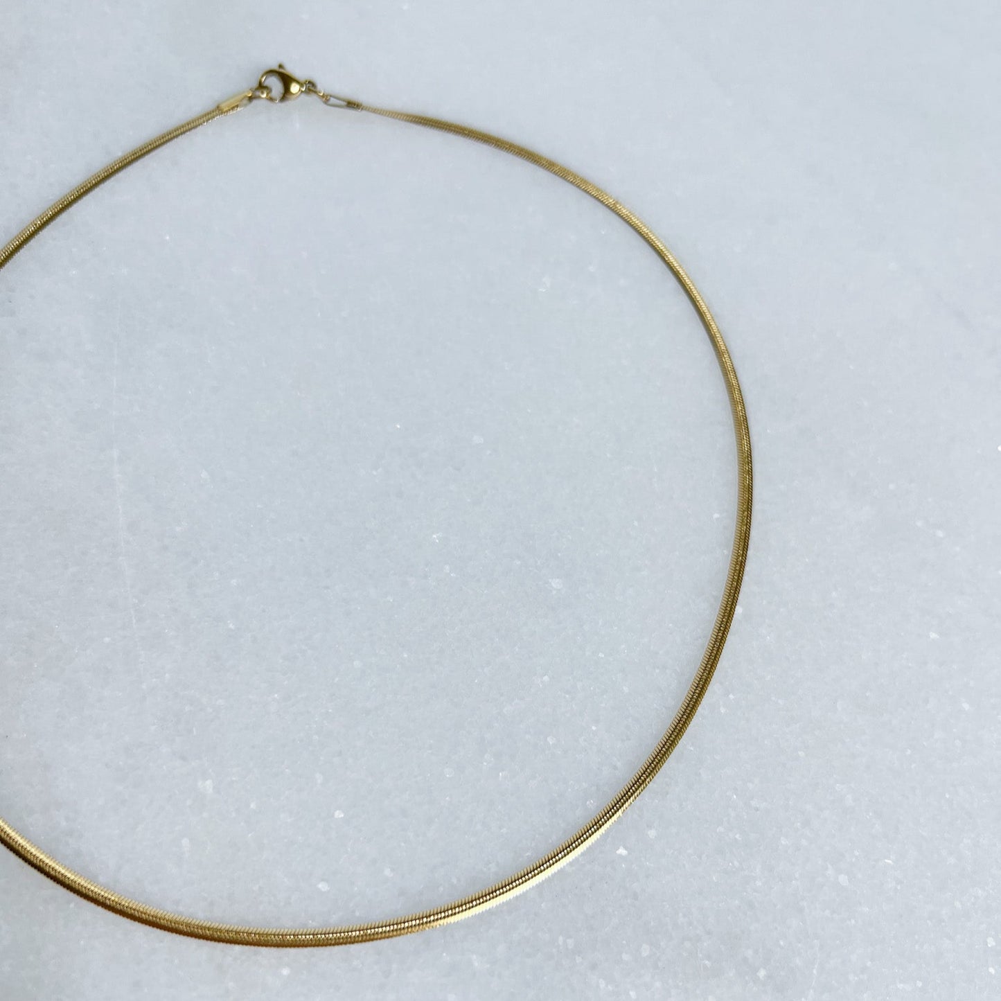 Gold 2mm herringbone chain on a white background