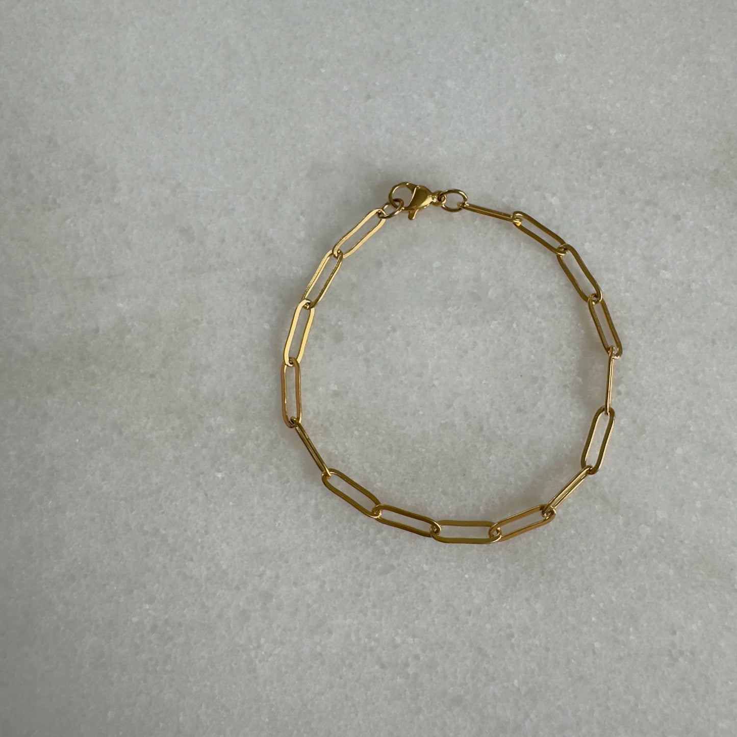 Gold Paperclip Bracelet on marble background