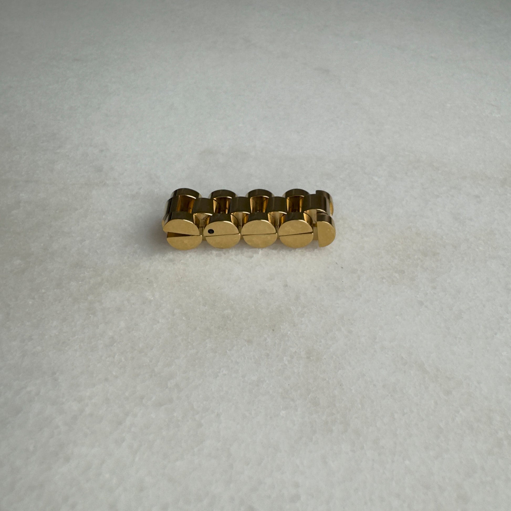 Gold watch link ring on marble background