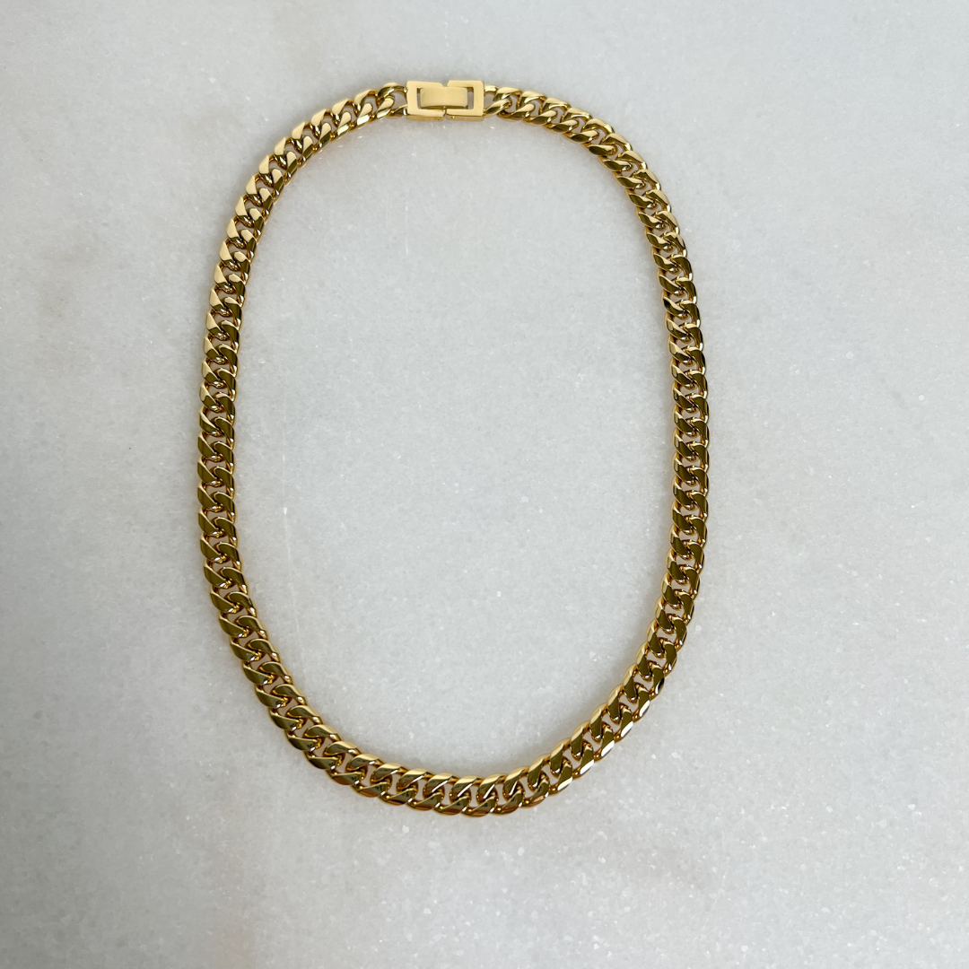 Gold 8mm Cuban Link Chain on marble background