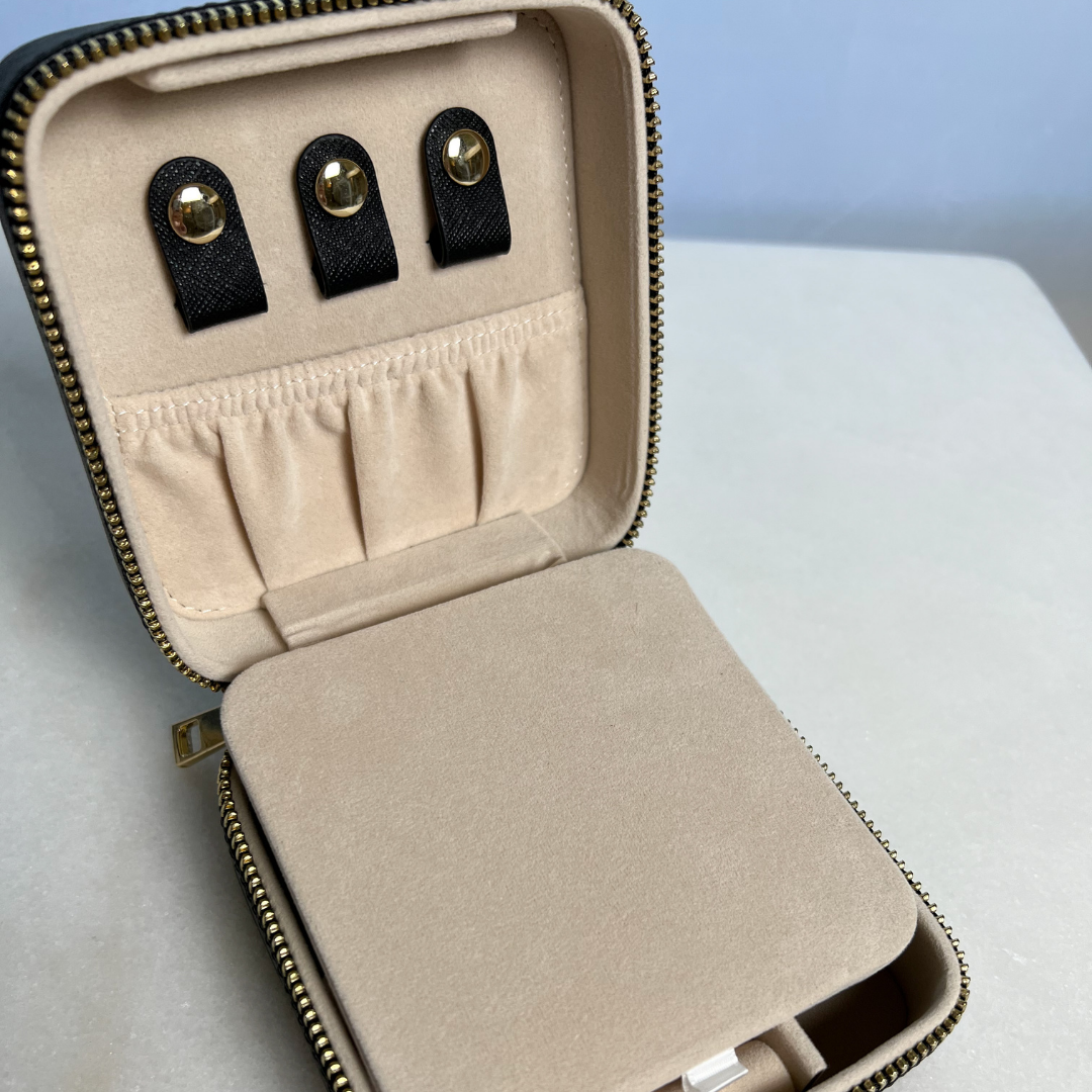 Open 4 inch x 4 inch Black Saffiano Leather Jewelry Travel Case with Gold Zipper Hardware showing loops for hanging necklaces