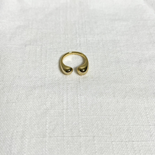 Load image into Gallery viewer, Gold u-shaped ring, rounded at the openings, on white linen background.
