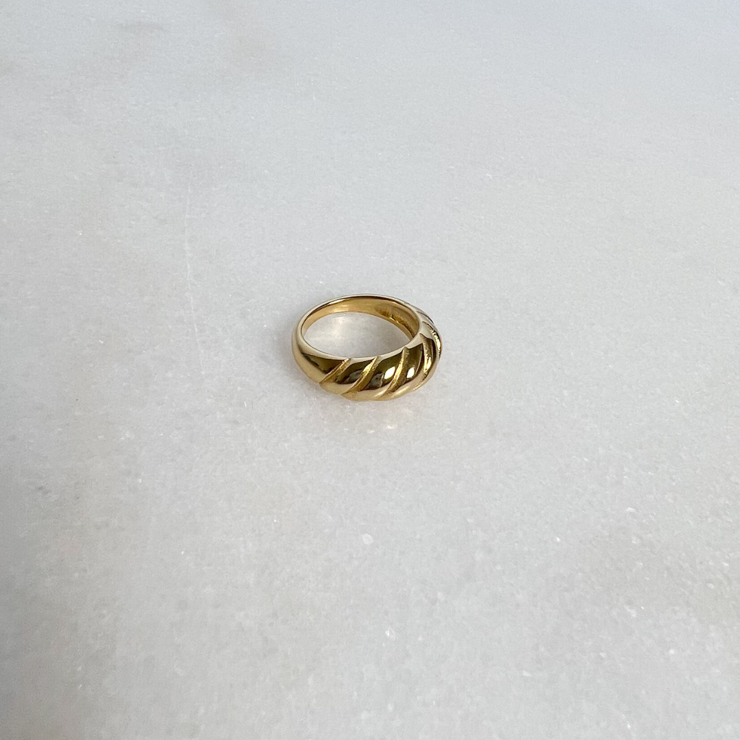 Gold Twist Ring on marble background