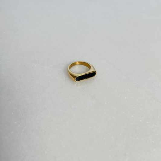 Black enamel bar ring on marble background